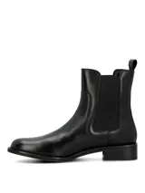Botas tipo Chelsea de cuero negro con paneles elásticos laterales, suela de goma y taco cuadrado bajo.
