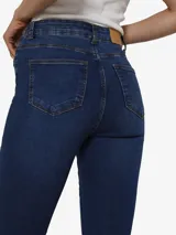 Jean flare de tiro alto en denim azul medio, con cierre de botón y cremallera. Presenta un lavado uniforme y un corte que se ajusta en el muslo y se ensancha desde la rodilla.