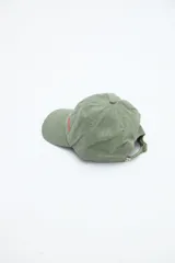 Gorra verde militar de diseño clásico con visera curva y bordado frontal en hilo rojo con la palabra "UNIFORM".