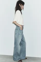 Jeans de tiro alto con corte recto, confeccionados en denim de lavado claro. Presentan bolsillos frontales tipo parche y costuras verticales decorativas en el frente.