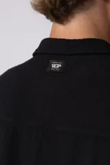 Camisa de hombre de manga corta color beige claro, confeccionada en lino. Tiene cuello clásico, cierre frontal con botones y corte recto.