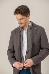 Saco sport de paño color marrón con pechera interna desmontable acolchada en tono gris topo, cierre frontal y solapas clásicas.