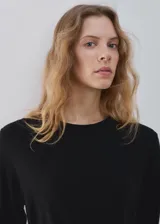Vestido midi negro de manga larga, con escote redondo, lazo ajustable en la cintura y tajo lateral.