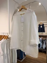 Camisa de lino color blanco, con cuello mao, mangas largas con puños vuelto y cierre frontal de botones.