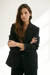 Blazer negro con bordado floral, hombreras, bolsillo interno y botones frontales y en mangas.