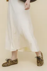 Mocasín tipo boat shoe color marrón, confeccionado en cuero, con cordones de cuero marrón y cordones decorativos azules.