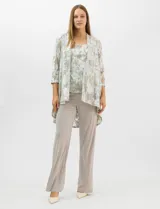 Conjunto de tres piezas compuesto por una musculosa de escote redondo, un cardigan abierto de mangas 3/4 y un pantalón de pierna ancha. La musculosa y el cardigan presentan un estampado abstracto con hilos metalizados, mientras que el pantalón es de color liso con cintura elástica.