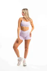 Top deportivo blanco con breteles finos y logo pequeño en el frente.