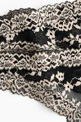 Pack de dos bombachas tipo colaless confeccionadas en encaje negro con detalles en tono beige. Presentan diseño de tiro bajo con bordes festoneados y un pequeño detalle de lazo en el centro.