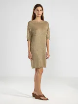 Vestido corto de punto con hilos metálicos que aportan un brillo sutil. Presenta un calce relajado, cuello redondo, mangas cortas y espalda en V pronunciada con detalle de dije metálico.