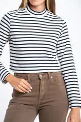 Polera de manga larga, corte ajustado al cuerpo, con cuello alto. Presenta un estampado de rayas horizontales en tonos marrón camel y azul marino.