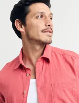 Camisa sport de manga corta, confeccionada en una mezcla de lino y algodón. Presenta cuello clásico, cierre frontal con botones de coco y un bolsillo aplicado en el pecho.