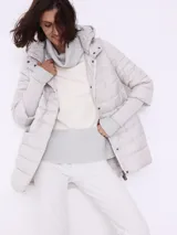 Campera corta matelassé color visón, con cuello alto, capucha desmontable y puños tejidos.