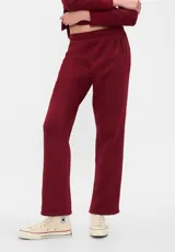 Pantalón deportivo de corte recto y tiro medio, color bordó, con cintura elástica y logo de la marca estampado en la parte superior de la pierna.