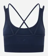 Top deportivo Get Over confeccionado en poliamida seamless, con escote redondo, breteles cruzados en la espalda y diseño sin costuras para mayor comodidad.