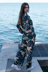 Pantalón largo de tela azul con estampado de guepardos y hojas.