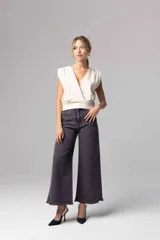 Pantalón denim azul oscuro de corte ancho con terminación desflecada.