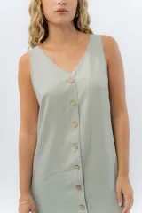 Vestido largo de lino con escote en V, diseño recto y fluido, con cierre frontal abotonado mediante botones de madera.