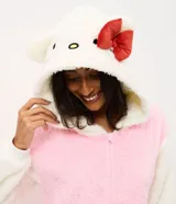 Pijama enterizo tipo mono confeccionado en tejido fleece de tacto suave y peludo. Presenta cierre frontal con cremallera y capucha integrada con diseño de la cara de Hello Kitty, incluyendo orejas en 3D y un lazo rojo aplicado.