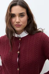 Cardigan de punto con textura de tejido estructurado, color bordó, con cuello redondo, cierre frontal de botones y mangas largas.