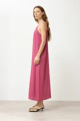 Maxi vestido fucsia con breteles finos y corte recto.