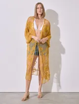 Kaftan largo color amarillo mostaza, de micro tul bordado con motivos florales. Tiene mangas largas y cordón ajustable en la cintura.