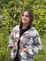 Saco abrigado de tejido texturizado en tonos marrones y negros, con diseño a cuadros, ribetes de lino en los bordes y cierre frontal con lazos.