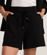 Short de corte recto y cintura alta, confeccionado en tejido airflow con textura arrugada. Presenta trabillas, lazo ajustable en la cintura, cierre tradicional y bolsillos laterales tipo carpintero.