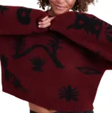 Buzo de punto color bordó con estampado gráfico en negro, cuello redondo, mangas largas y corte holgado tipo crop.