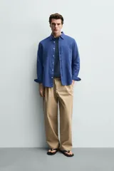 Camisa regular fit celeste confeccionada en mezcla de lino y algodón, con cuello abotonado, manga larga, bolsillo frontal en el pecho y cierre de botonadura.