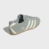 Championes Adidas modelo Tokyo, de diseño retro y corte bajo. Confeccionados en gamuza color verde grisáceo con las icónicas tres tiras laterales en color crema y suela de caucho color caramelo.