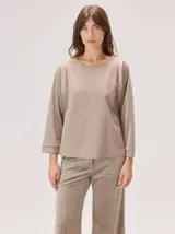 Camisa de corte holgado con cuello redondo y mangas tres cuartos. Presenta un diseño de paneles combinados en diferentes texturas y tonos de beige, con puños ajustados.