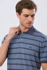 Remera polo de manga corta con diseño de rayas horizontales en color azul marino y rosado. Cuenta con cuello camisero, cierre frontal con botones y calce clásico.