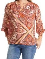 Blusa de gasa estampada con diseño de arabescos en tonos tierra. Presenta cuello a la base con escote en V, hombros con detalle de punto smock y mangas 3/4 con puños anchos también en punto smock.