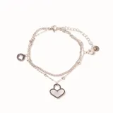 Pulsera de acero plateado de doble cadena con dijes. Incluye un dije de corazón con nácar, un dije de estrella calada y un dije de cristal redondo.