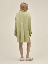 Camisa larga color crema confeccionada en lino-tencel con botones de conchas naturales y bolsillos laterales.