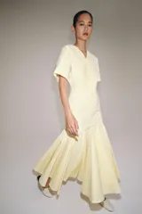 Vestido largo de Zara Woman Collection color amarillo claro, confeccionado en mezcla de algodón. Cuenta con escote en V, manga corta, corte en la cintura y falda evasé con pliegues marcados.