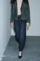 Jeans de tiro alto con corte barrel y diseño tapered, confeccionados en denim con efecto lavado y detalle de raya planchada. Presentan cintura con trabillas, cierre frontal con cremallera y botón, y bolsillos funcionales en delantero y espalda.