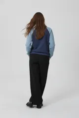 Buzo de cuello redondo con diseño color block en azul marino y celeste, con mangas raglán y costuras blancas decorativas.