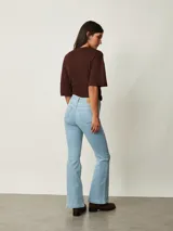 Pantalón de jean negro de corte flare, con tiro medio y bolsillos delanteros y traseros.