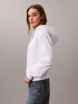Buzo con capucha Calvin Klein, color blanco, de corte clásico con puños y dobladillo en punto canalé. Presenta cordones ajustables en la capucha y un pequeño logotipo bordado en el pecho.
