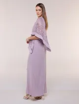 Vestido largo azul marino de seda fría, compuesto por una falda recta con tajo frontal y una capa superior superpuesta de encaje con lentejuelas bordadas, escote a la base y mangas tres cuartos acampanadas.