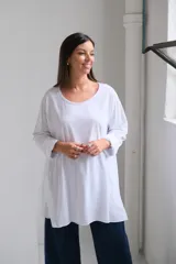 Remera blanca de corte oversize y diseño holgado, con cuello redondo y mangas largas con puños doblados.