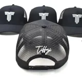 Gorra tipo trucker color negro con panel frontal rígido y parte trasera de malla. Presenta un bordado frontal en color blanco con el logo de la marca.