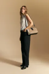 Top sin mangas de jacquard color negro, con cuello cerrado y silueta recta. Presenta una textura trabajada con relieve y una terminación suavemente ondulada en el ruedo.