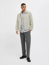 Campera aviadora color beige, de corte clásico, con cuello camisero, cierre frontal con cremallera, bolsillos laterales y puños elastizados.