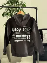 Canguro negro oversize de felpa, con capucha, bolsillo tipo canguro y diseño estampado en la espalda con gráficos estilo streetwear y texto en blanco.