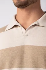 Remera tejida con cuello polo y rayas horizontales en tonos beige y crema, corte oversize y mangas cortas. Confeccionada en hilado de algodón.