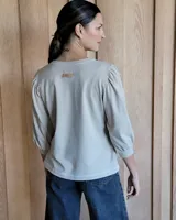 Remera de algodón con cuello redondo y mangas abullonadas de textura diferenciada. Presenta un diseño versátil con cuerpo de algodón y mangas de tussor al tono.