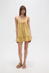 Vestido corto de algodón con textura arrugada, escote en V con cordón ajustable y detalle de volado en el ruedo.